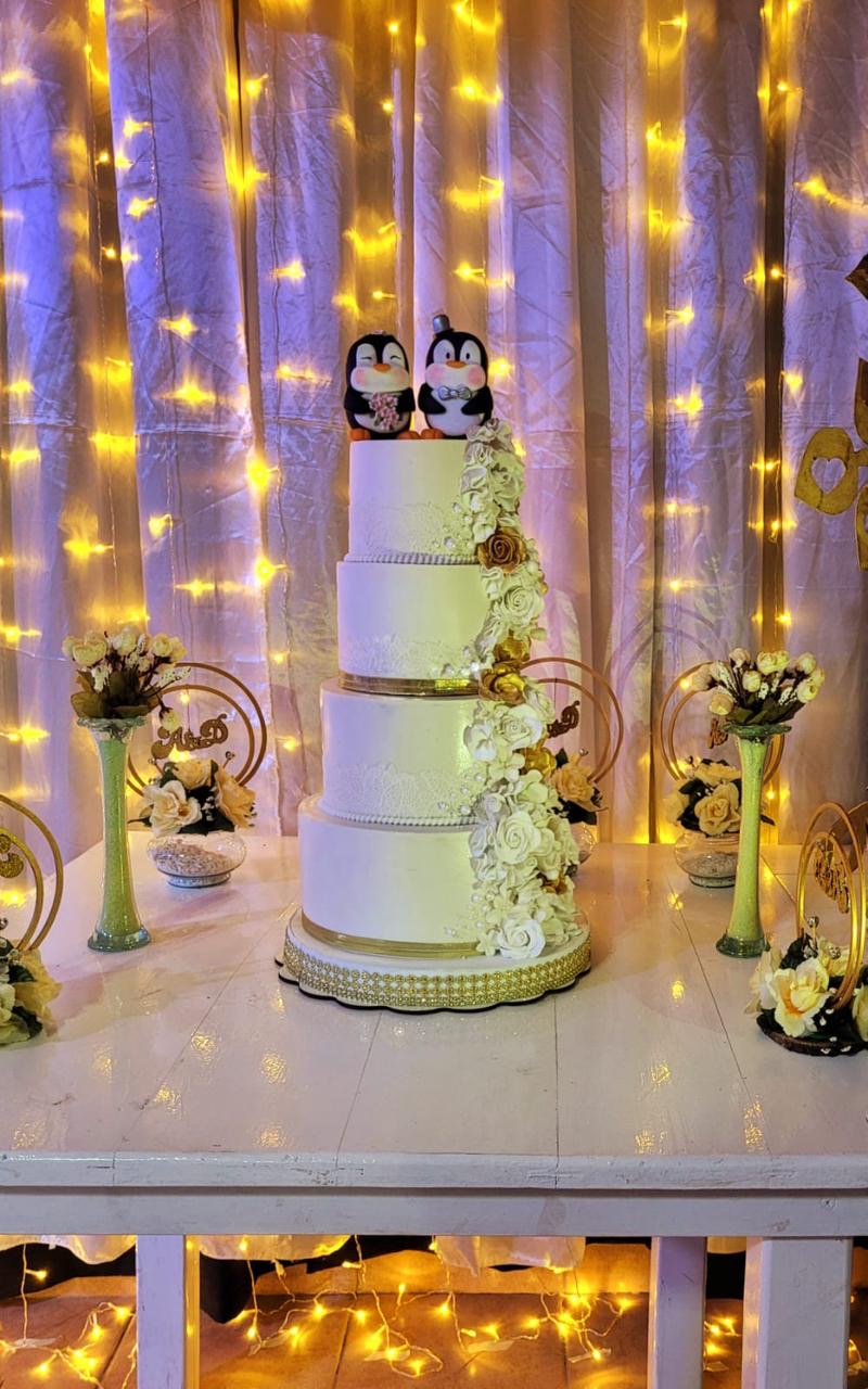 Torta de bodas de varios pisos con flores blancas y doradas